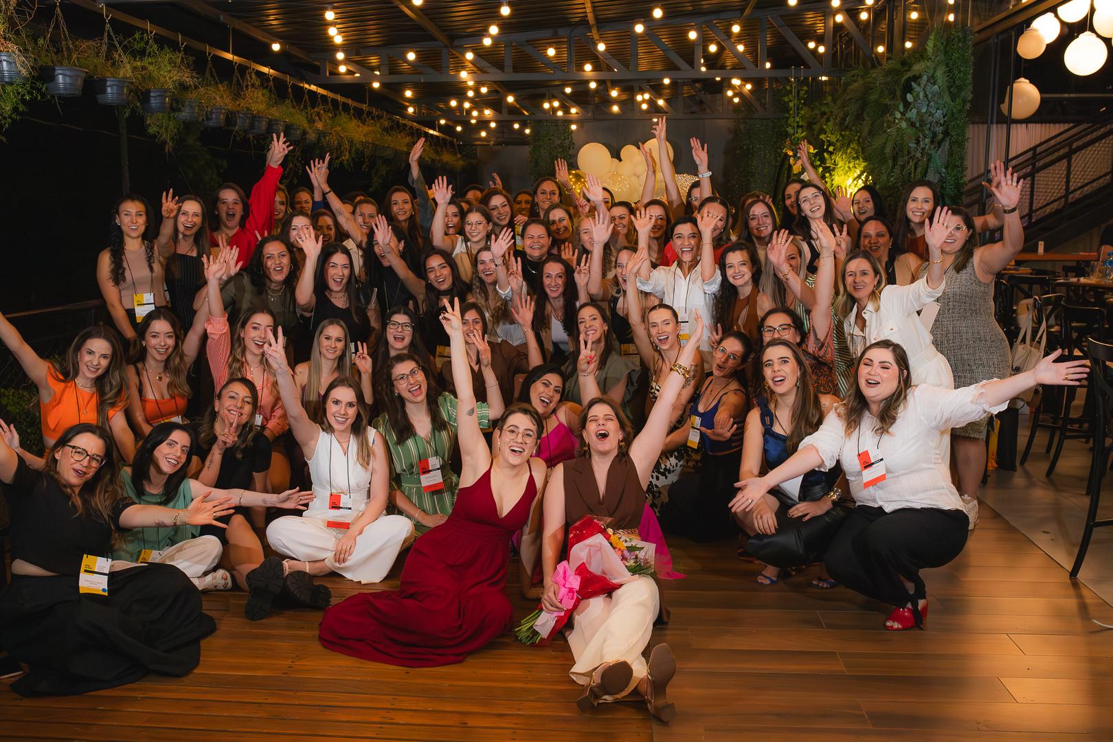 Grupo de mulheres comemorando juntas em uma edição do Elas no Bar